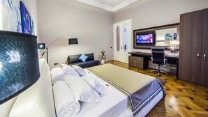 A modern hotel room with a bed, a desk, a television, and a wardrobe. - Matei Corvin Apartments (Cluj-Napoca)