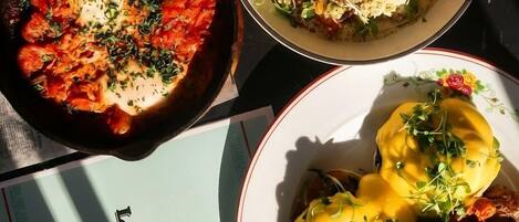 A table with various dishes, a coffee cup, and a menu.