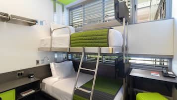 Un lit superposé avec une échelle, un bureau et une fenêtre avec des stores.