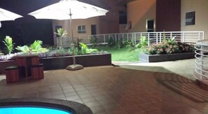 Outdoor pool, pool umbrellas - Ponderosa Travel Lodge (Kwabenya)