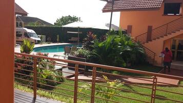 A pool area with a staircase, a white van, and a person carrying a bag.