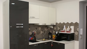 Una cocina compacta con refrigerador, microondas, pileta y alacenas.