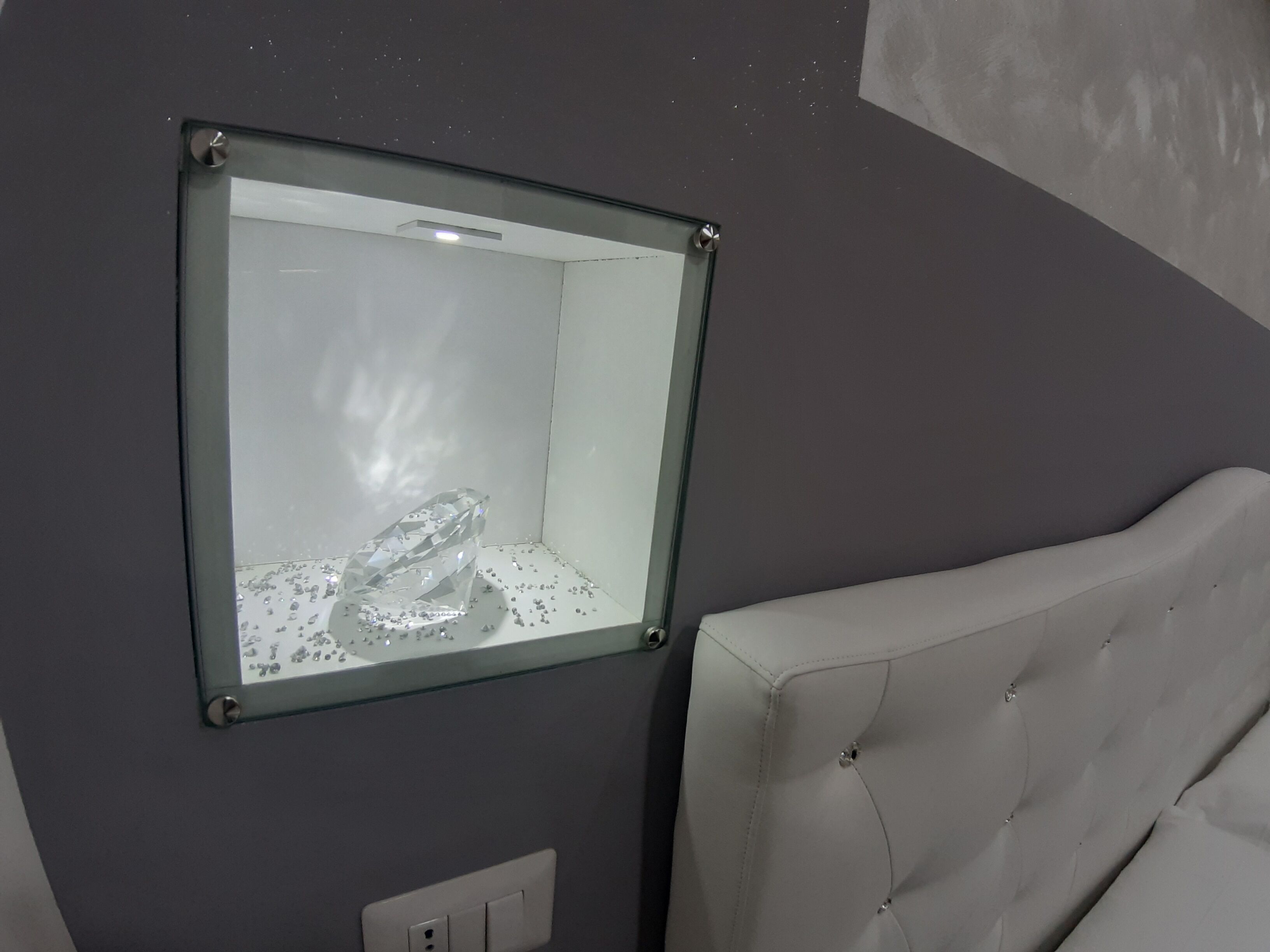 A room with a glass display case containing a large crystal.