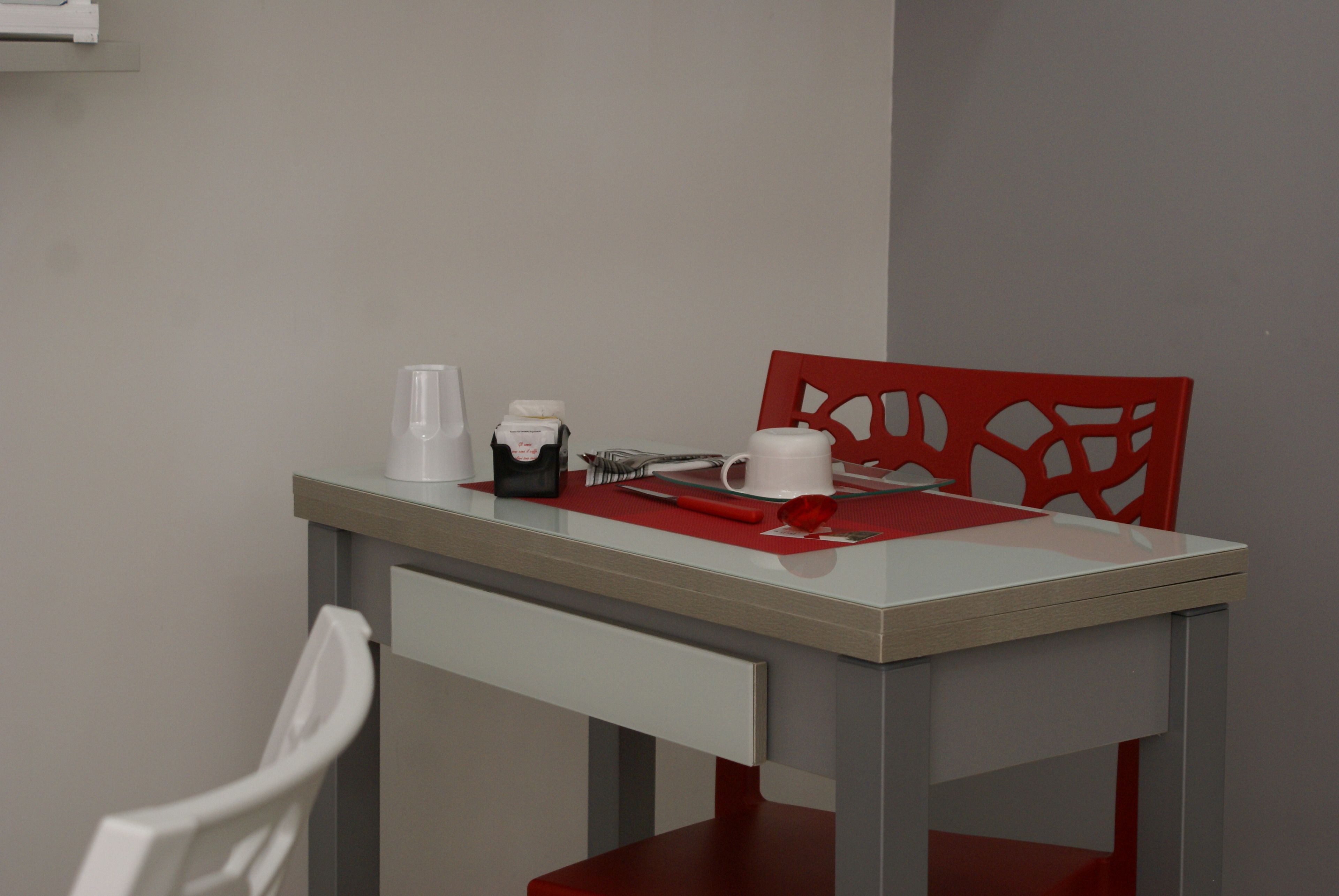A dining area with a table, chairs, and a coffee maker.