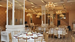 A banquet hall with round tables, gold chairs, and chandeliers. - Madame Tadia Hotel (Eskisehir)