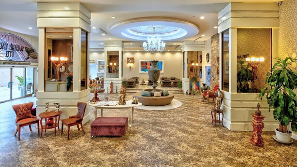 A spacious lobby with a central seating area, a chandelier, and a large mirror reflecting the room. - Madame Tadia Hotel (Eskisehir)