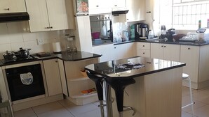 A modern kitchen with white cabinets, a black countertop, and a stainless steel island.