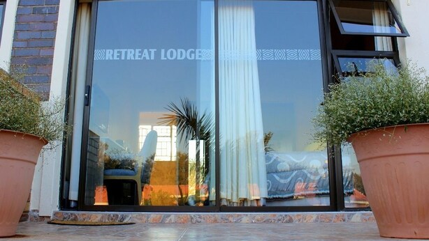 A building entrance with a glass door labeled "RETREAT LODGE".