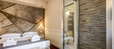 Une chambre d’hôtel moderne dotée d’un grand lit, d’une douche en verre et d’un mur à texture.