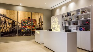 A reception area with a modern design, featuring a wooden wall with graffiti art, a reception desk, and shelves with various items. - Fiesta Inn Express Ciudad de México Forum Buenavista (Mexico City)