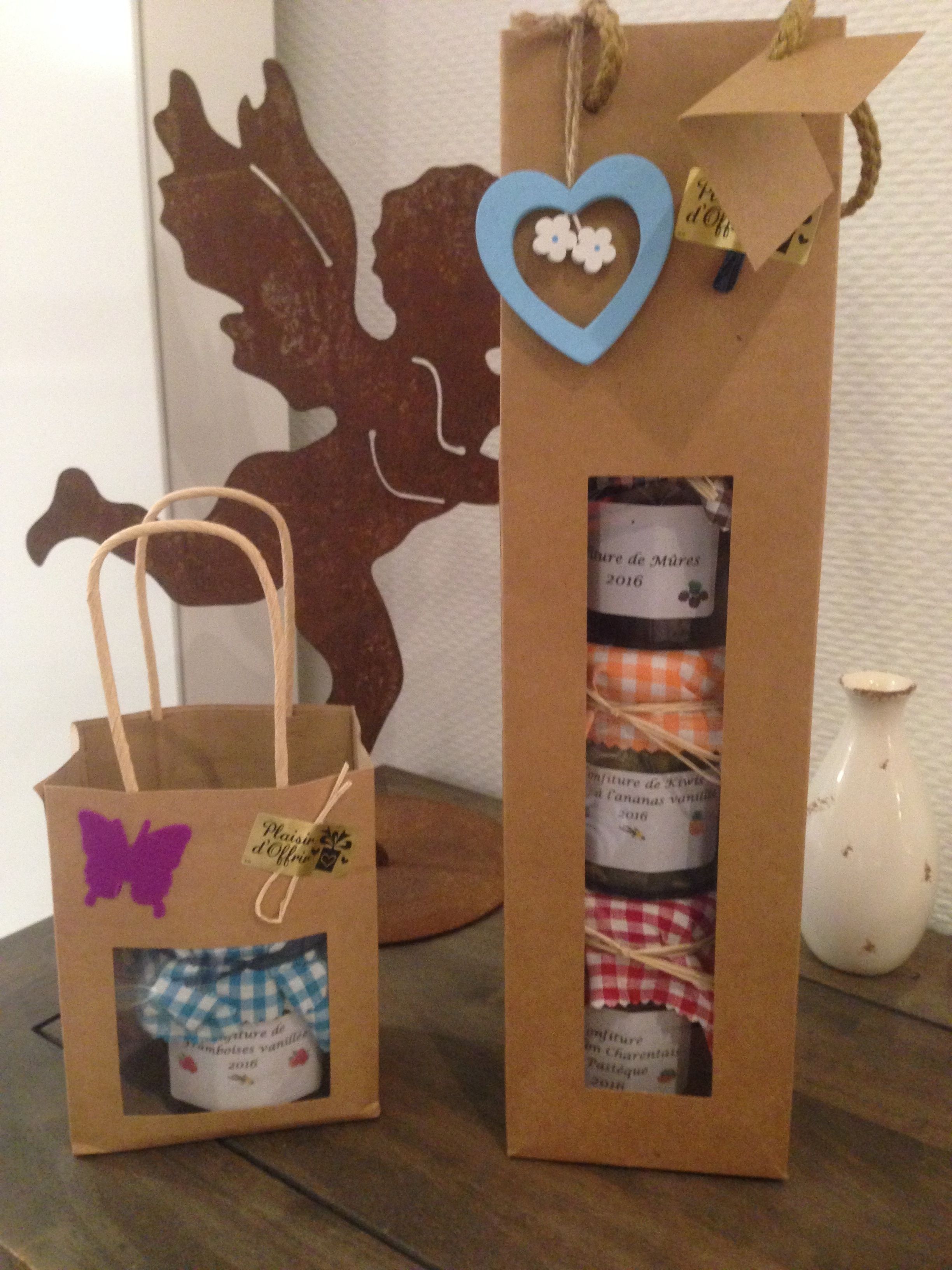 Two gift bags with ribbons and tags, placed on a wooden surface.