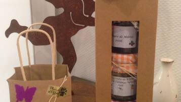 Two gift bags with ribbons and tags, placed on a wooden surface.