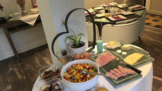 A breakfast buffet with various food items and a glass of juice.