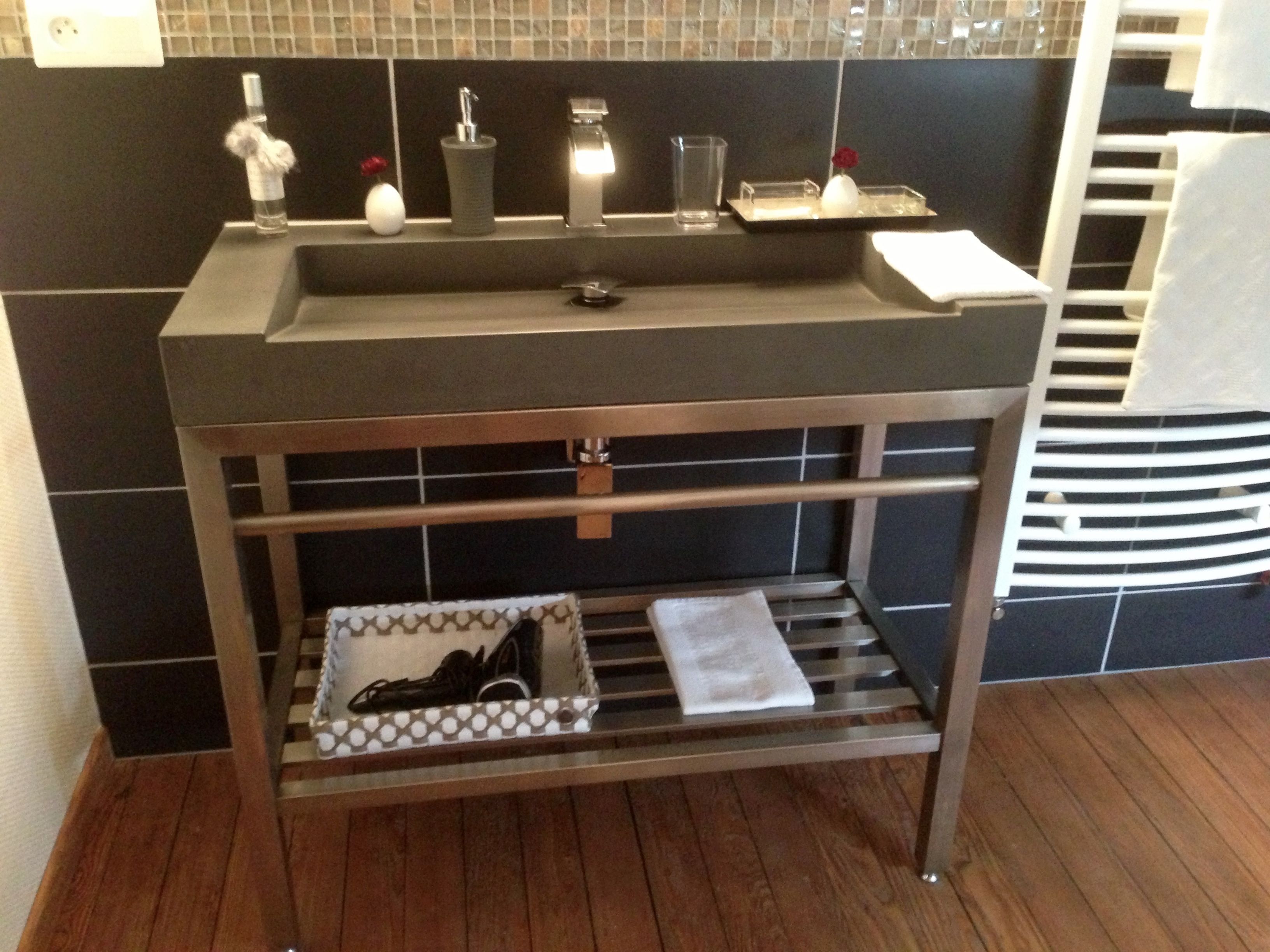 A bathroom with a modern sink, a mirror, and a towel rack.