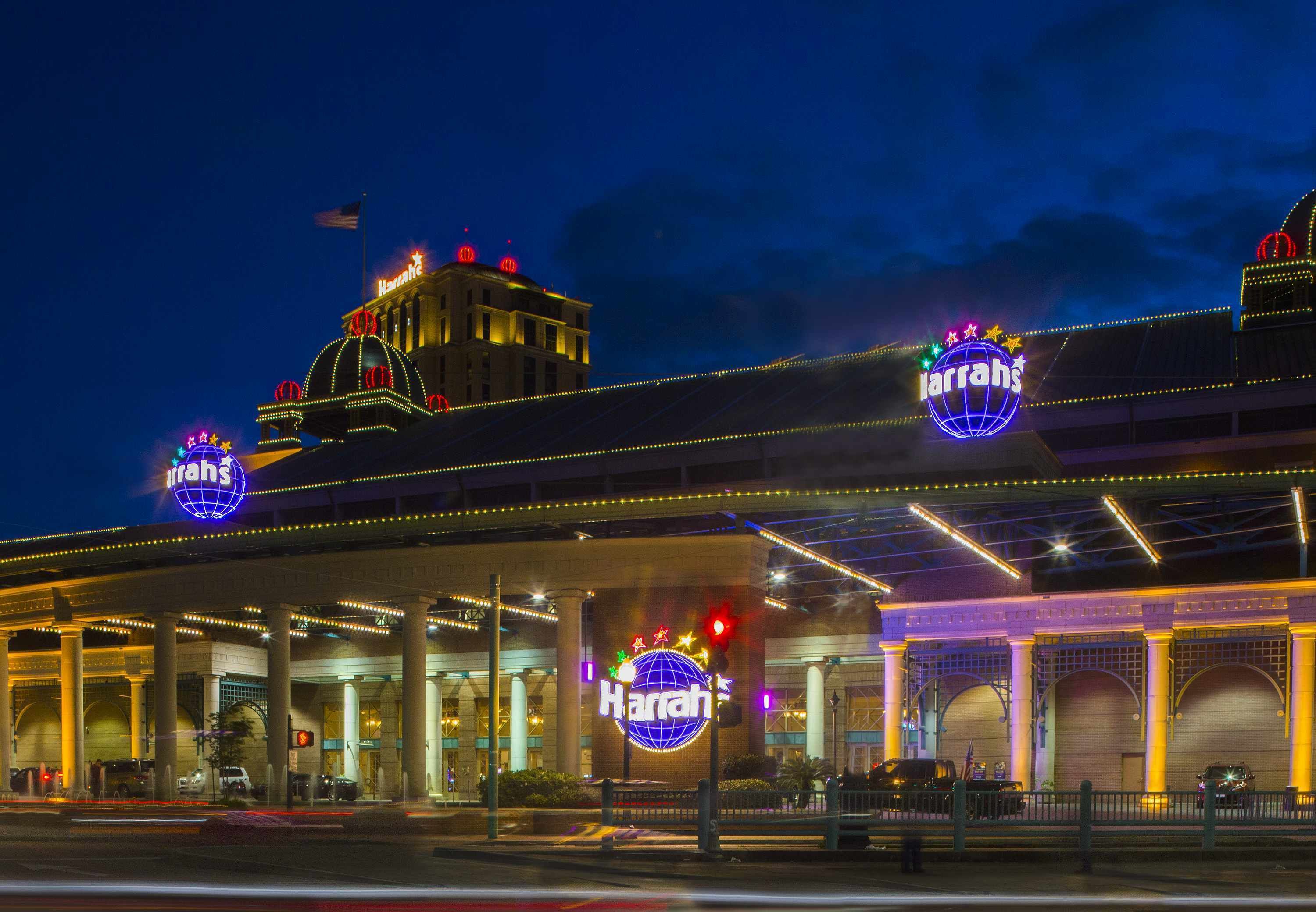 Un hotel bien iluminado con un gran letrero que dice 'Harrath's' y un logotipo con un globo terráqueo.