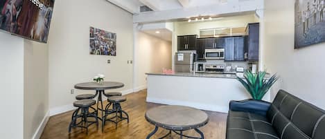 A modern kitchen with dark cabinets, a central island, and stainless steel appliances.