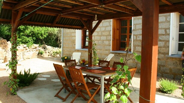 An outdoor covered patio with a table and chairs, stone walls, and greenery. - House / Villa - Port-Vecchio (Porto-Vecchio)
