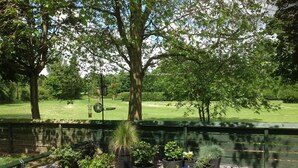 A garden area with various potted plants and a pathway. - Excellent ground floor 2 Bed apt overlooking golf course with private parking. (Watton)