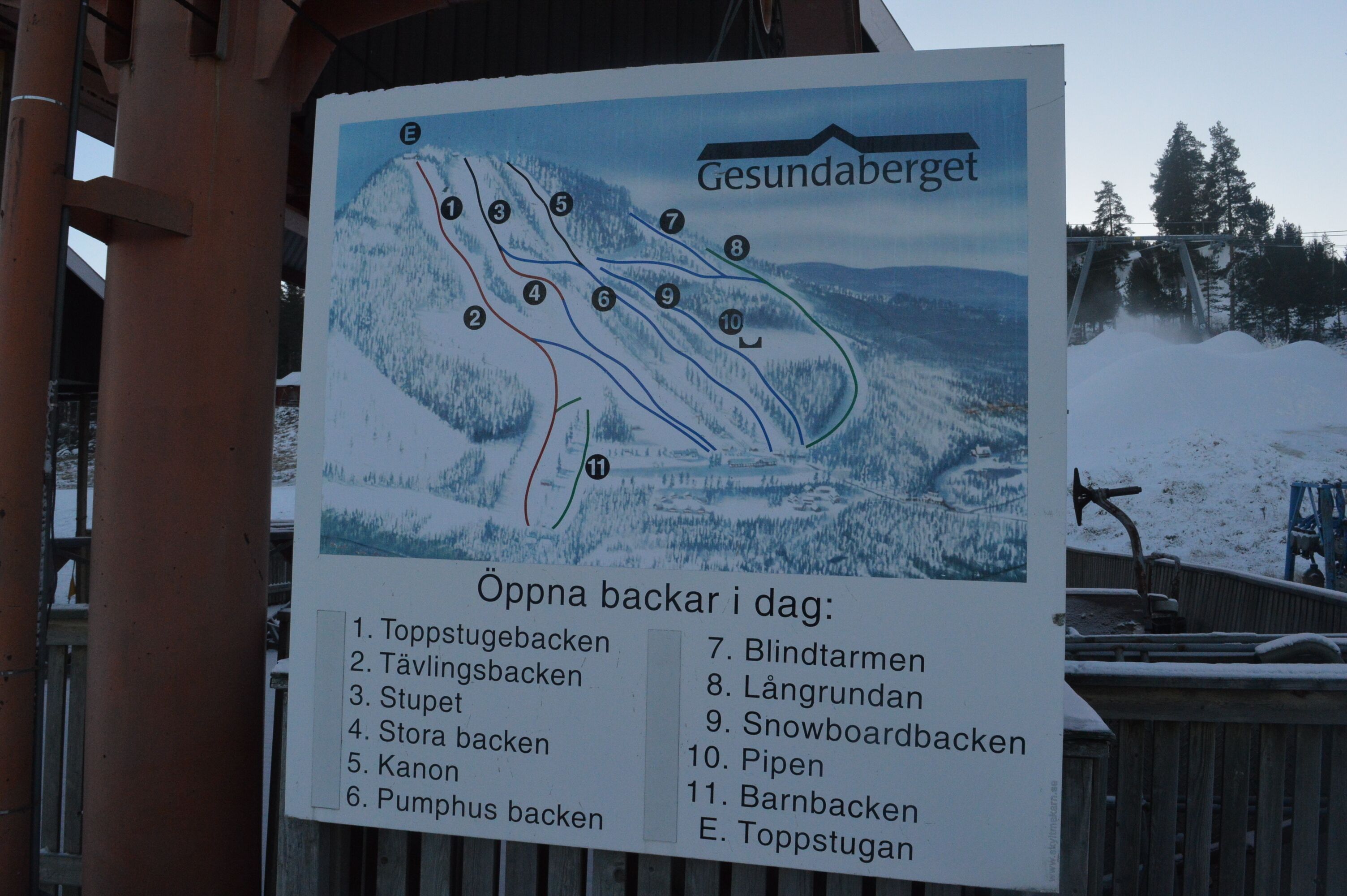 Ein Schild mit einer Pistenkarte und einer Aufzählung der Abfahrten.