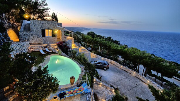 A modern villa with a swimming pool, stone architecture, and a view of the sea. - Luxury Villa & Spa (Gagliano del Capo)