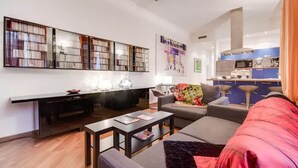 A modern living room with a sofa, coffee table, and a bookshelf. - LuxRent Loft Lagrange Sauna Gym (Torino)