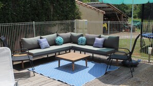 A deck with a sectional sofa, a wooden table, and outdoor chairs. - Spacious 3 Bed Gite, Aude, Pool, Hot Tub, Free Wi-fi, Games Room, Pet-Friendly! (Arques)