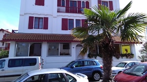 A multi-story building with red shutters and a tiled roof. - Promo Aptn2 T3 and garden 50 meters from the beach  (Hendaye)