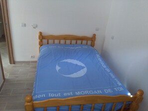 Un petit lit avec un protège-matelas bleu orné d’un logo et d’un texte.