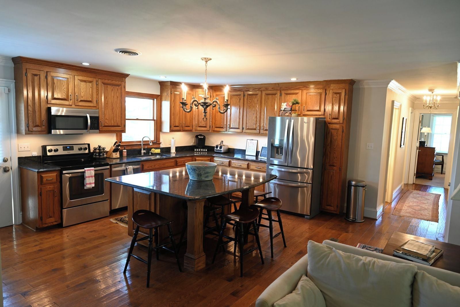 A modern kitchen with wooden cabinets, stainless steel appliances, and a central island with bar stools.