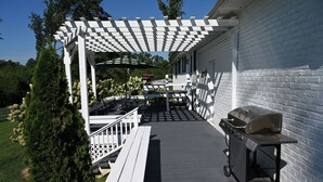 Estar alpendre coberto com churrasqueira, assentos e pérgola.