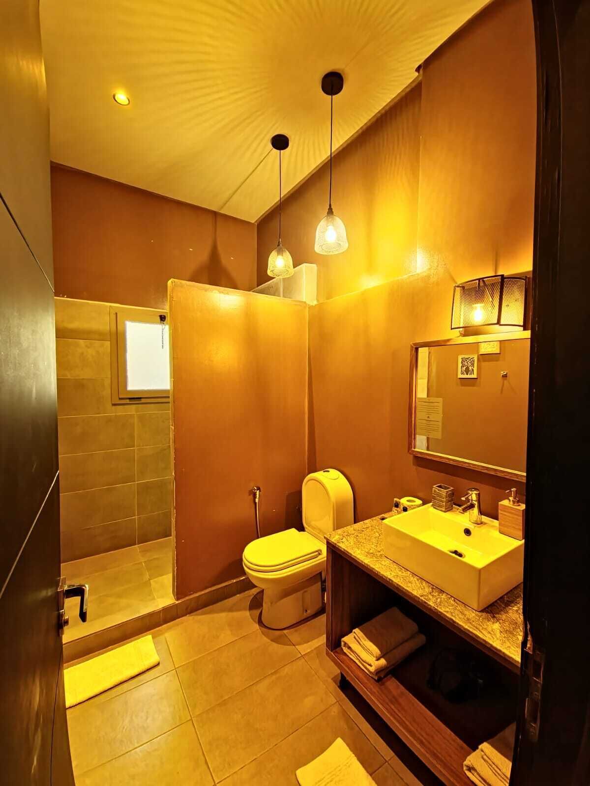 Een moderne badkamer met douche, toilet en wastafel.