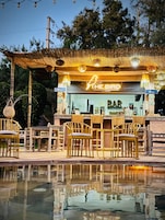 Una piscina al aire libre, sombrillas, sillones reclinables de piscina