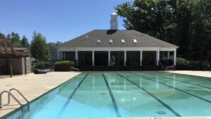 A swimming pool with a 'NO DIVING' sign, surrounded by a covered pavilion and trees. - Cute and spacious single family home, pet friendly (Charlotte)