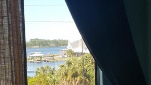 A room with a window overlooking a body of water, a dock, and some greenery. - Lagoon view within walking distance to the beach. One mile from the Hangout  (Gulf Shores)
