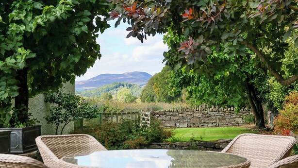 A garden with wicker furniture and a stone wall. - Very spacious rural retreat, walk to Crieff — Couples, Families, Pets Welcome. (Crieff)