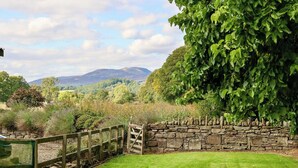 A stone wall with a wooden gate, a grassy lawn, and a view of hills and trees. - Very spacious rural retreat, walk to Crieff — Couples, Families, Pets Welcome. (Crieff)