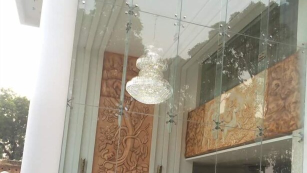 A modern building with a large glass facade, decorative wall panels, and potted plants. - Babian Imperial Resort (Lucknow)