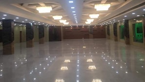 A spacious, well-lit hallway with a polished floor, recessed lighting, and marble pillars. - Babian Imperial Resort (Lucknow)