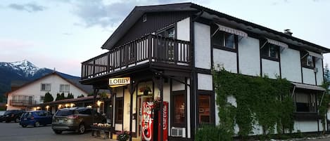 A two-story building with a balcony and a Coca-Cola vending machine.