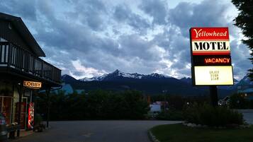 A motel sign with a mountain backdrop, a lobby sign, and a Coca-Cola sign.