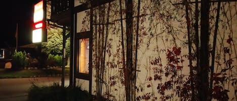 Un bĂątiment dotĂ© dâune façade en bois et dâune fenĂȘtre donnant sur un jardin.