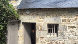 A stone building with a wooden door and a small window. - Charming old quiet house with garden - Village and sea on foot (Arradon)