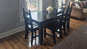 A dining area with a wooden table and chairs, a vase of flowers, and a sign that says 'be kind.' - Beautiful, remodeled penthouse in Lebanon Ohio, between Dayton and Cincinnati (Lebanon)