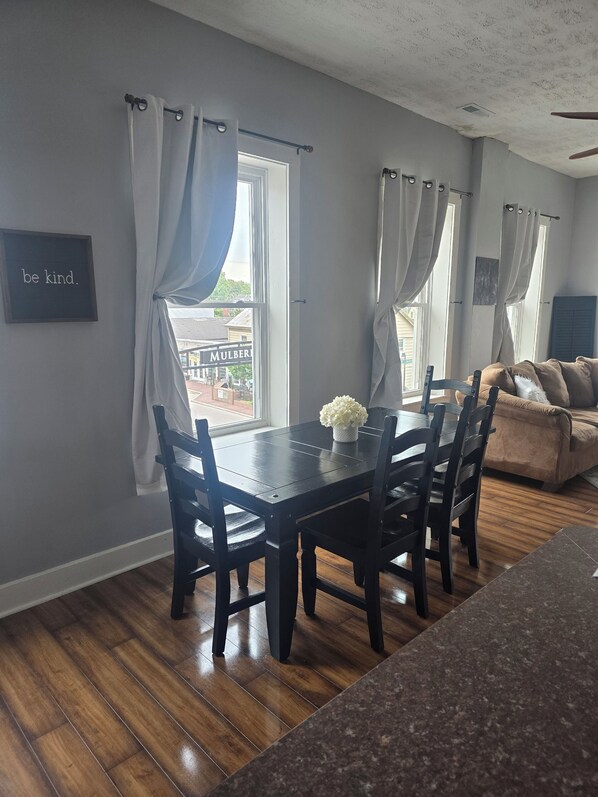 A dining area with a wooden table and chairs, a vase of flowers, and a sign that says 'be kind.' - Beautiful, remodeled penthouse in Lebanon Ohio, between Dayton and Cincinnati (Lebanon)