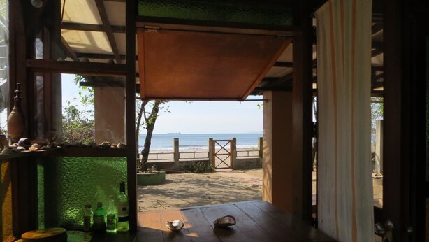Una mesa de madera con vista a la playa y al océano.