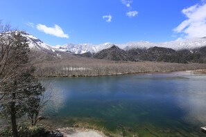 A lake surrounded by mountains with snow-capped peaks and clear blue sky. - Taisyoike Hotel, Kamikochi (Matsumoto)