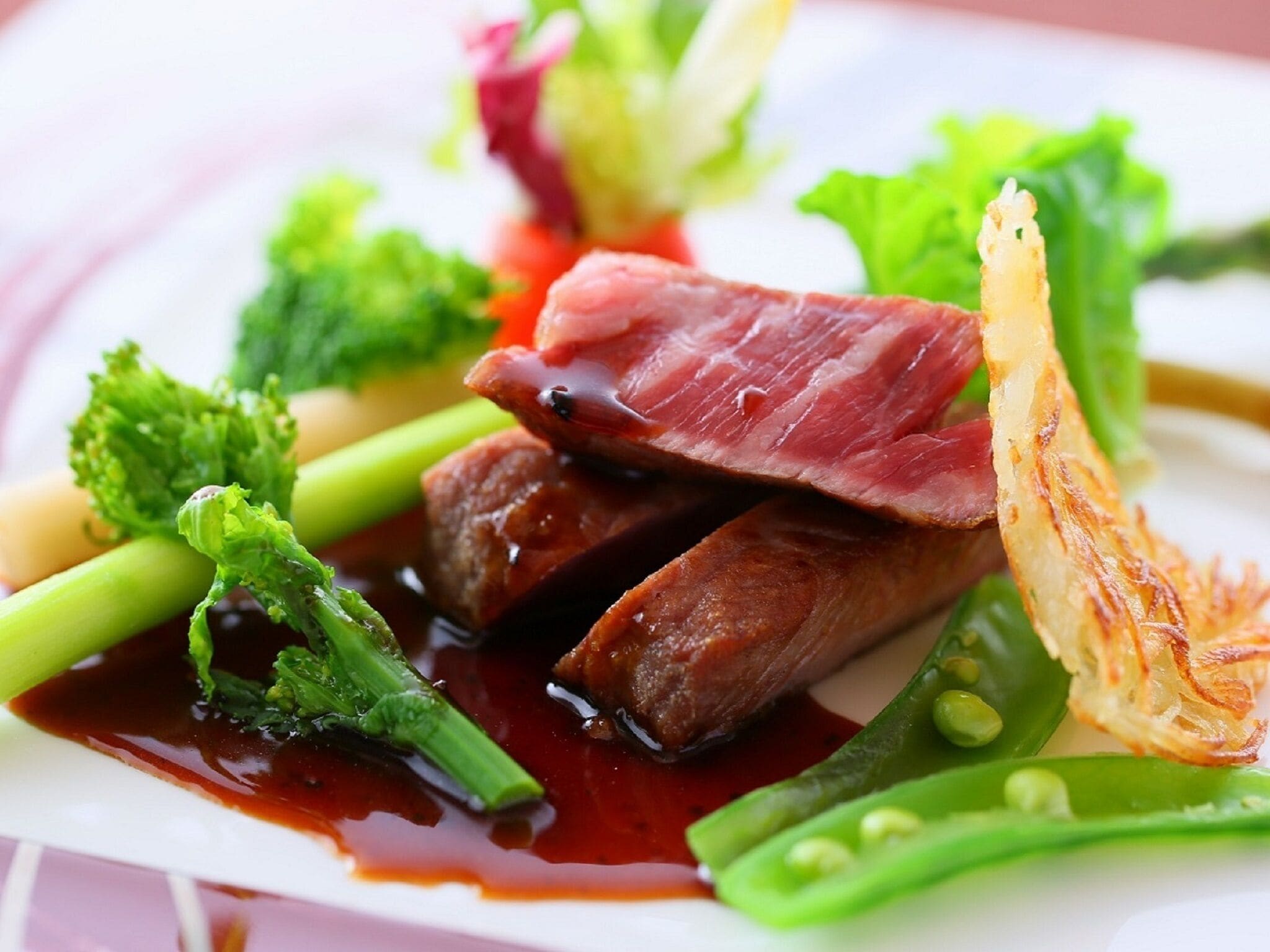 Un plato de comida con diferentes verduras y un trozo de carne.