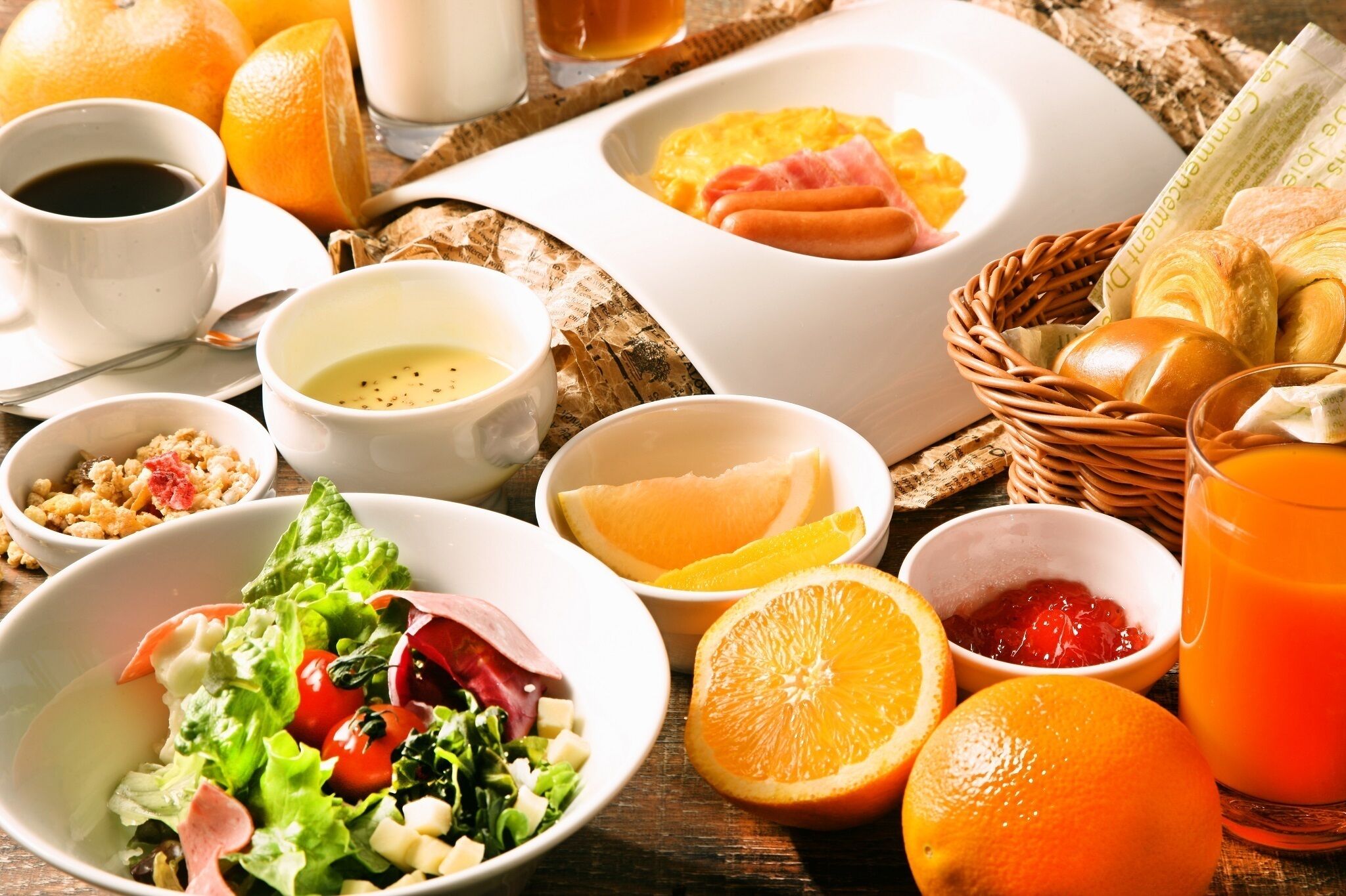 Un desayuno con diversas opciones de comida, como huevos, salchichas, tostadas y una ensalada.