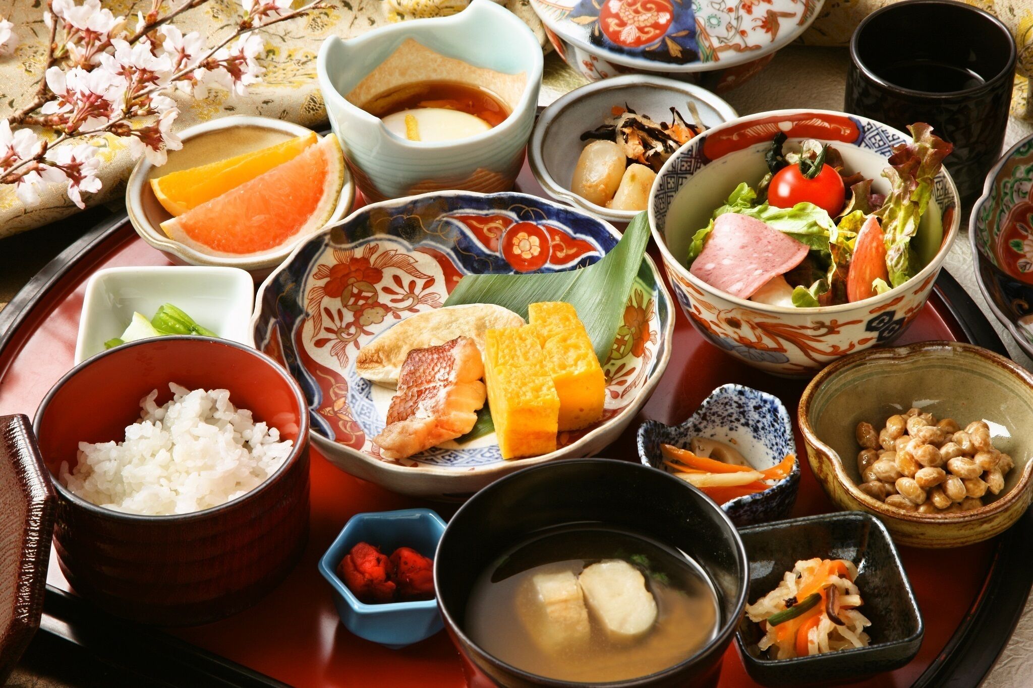 Una comida tradicional japonesa con diversos platos que incluyen arroz, pescado y verduras sobre una bandeja.