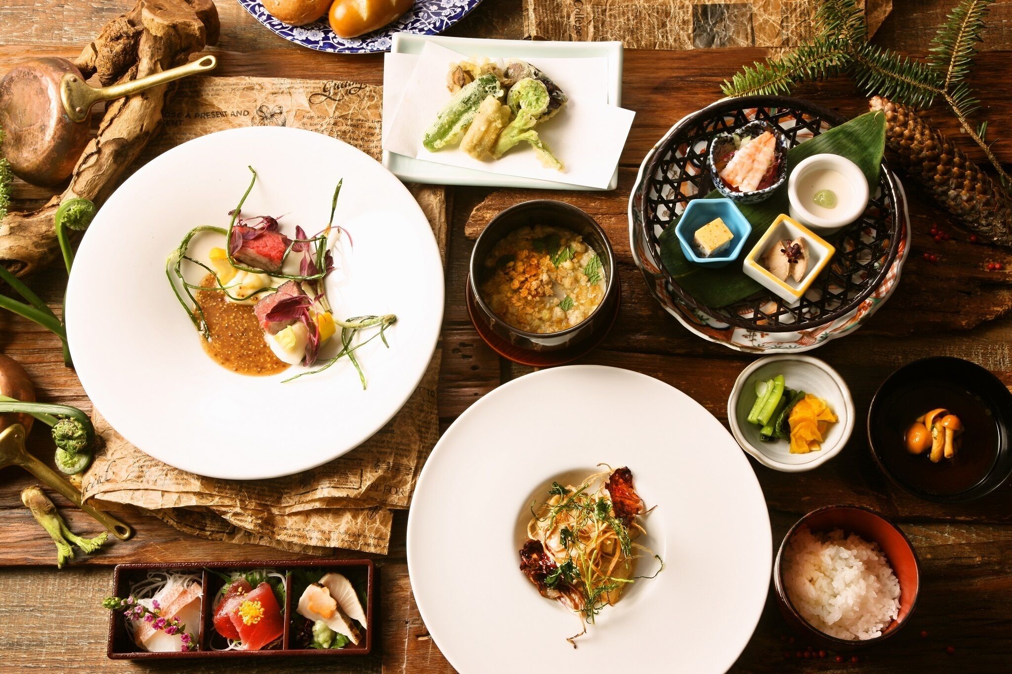 Verschiedene Gerichte auf einem Holztisch, darunter Sushi, Sashimi und weitere Spezialitäten der asiatischen Küche.